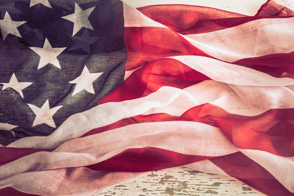 National Patriotic symbols. American flag on old white wooden background.The concept of patriotism and celebration